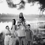 A joyful family enjoying time by the lake in a serene setting.